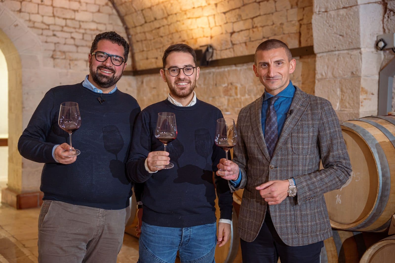 The team raising a glass in the barrel cellar at Borgo Egnazia